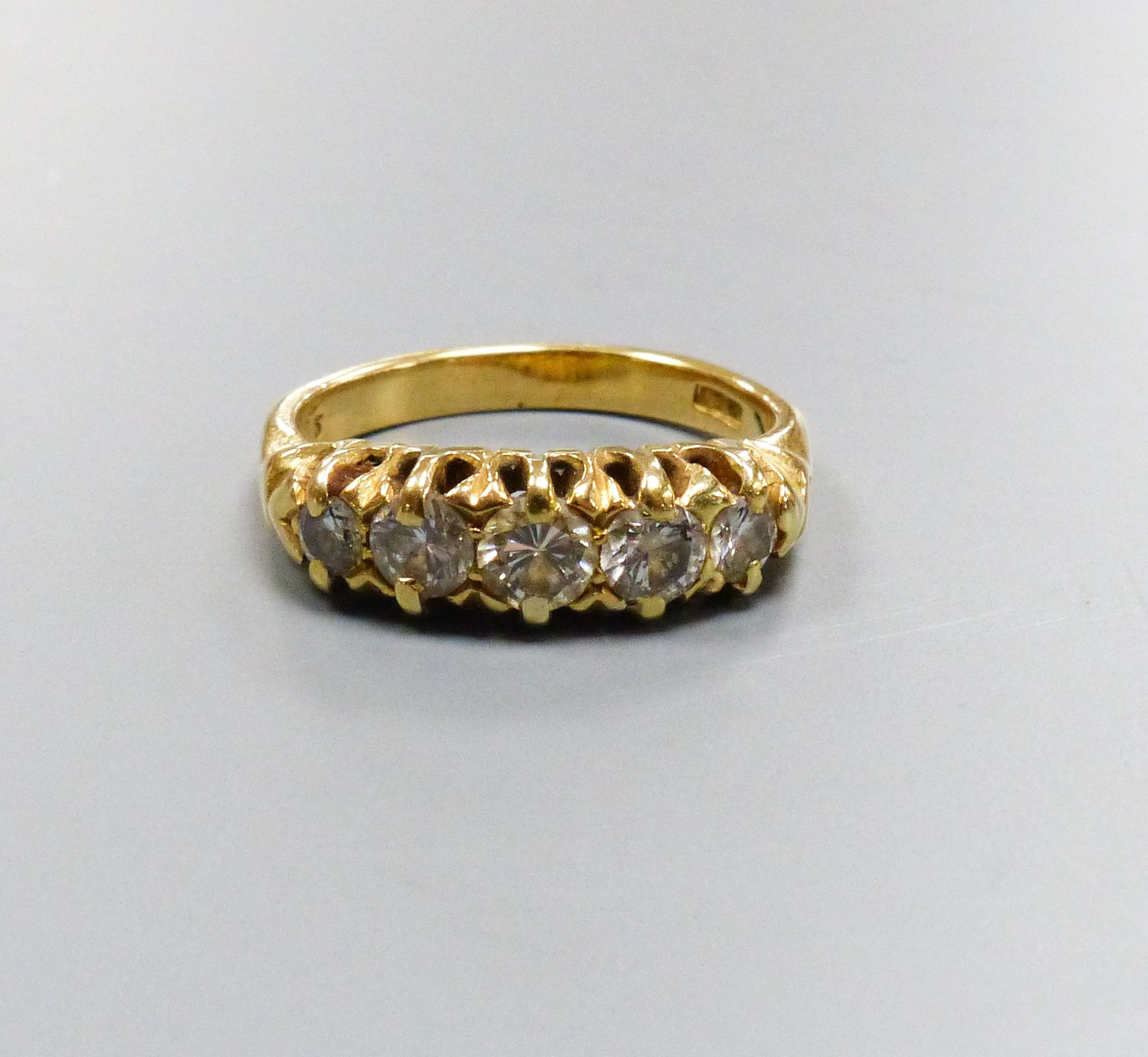 A five-stone diamond ring, 18ct yellow gold setting, claw-set with carved shoulders, size K, gross 5.5 grams.